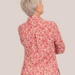 Femme senior vue de dos portant une chemise rose rouge à fermetures aimantées fabriquée en France - forESTIME